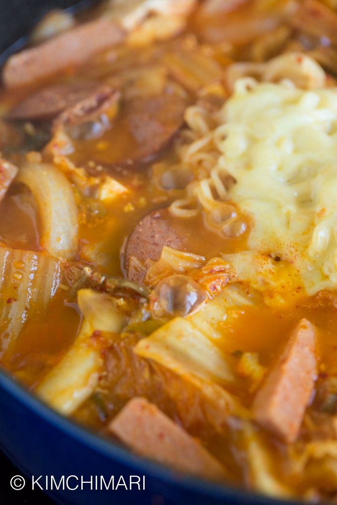 Close up of Budae Jjigae boiling and bubbling with cheese melting