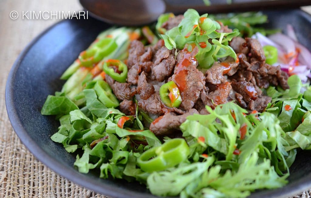 Bulgogi Rice Bowl with fresh greens topped with Gochujang sauce