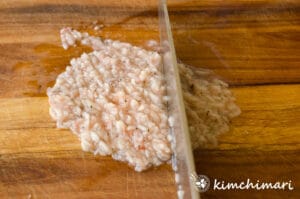 saewujeot being chopped on wooden cutting board