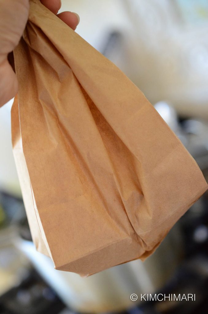 Coating chicken with corn starch in paper bag for korean fried chicken