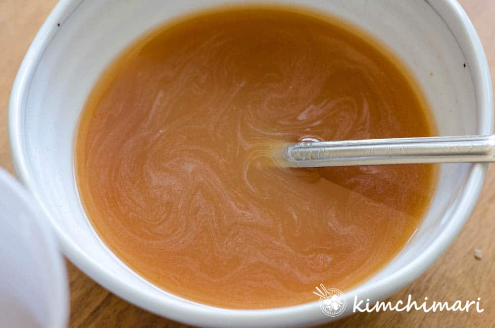 cold kimchi soup in bowl with spoon