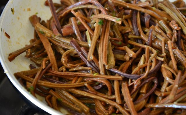 Cooked bracken fiddleheads seasoned in bowl