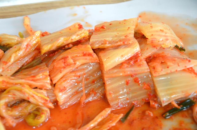 Cabbage Kimchi cut into slices on cutting board