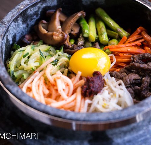 Bibimbap in Stone Pot with vegetable and meat toppings and egg yolk