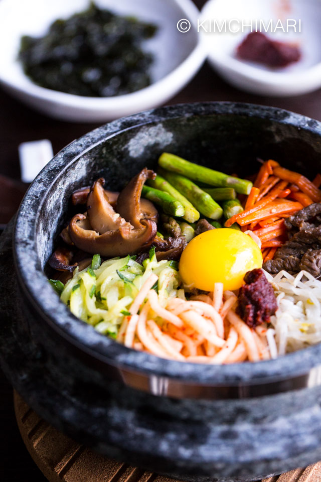 bibimap in grey stone pot with raw egg yollk and gochujang on top