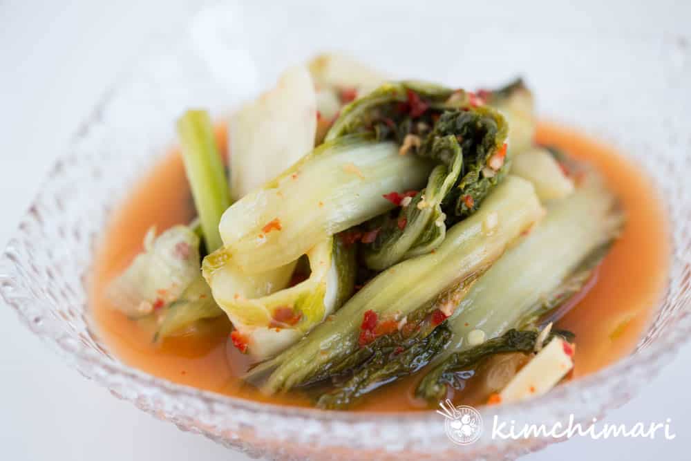 close up side view of ripe putbaechu kimchi in glass bowl