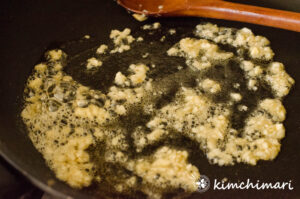 garlic cooking in oil in frying pan