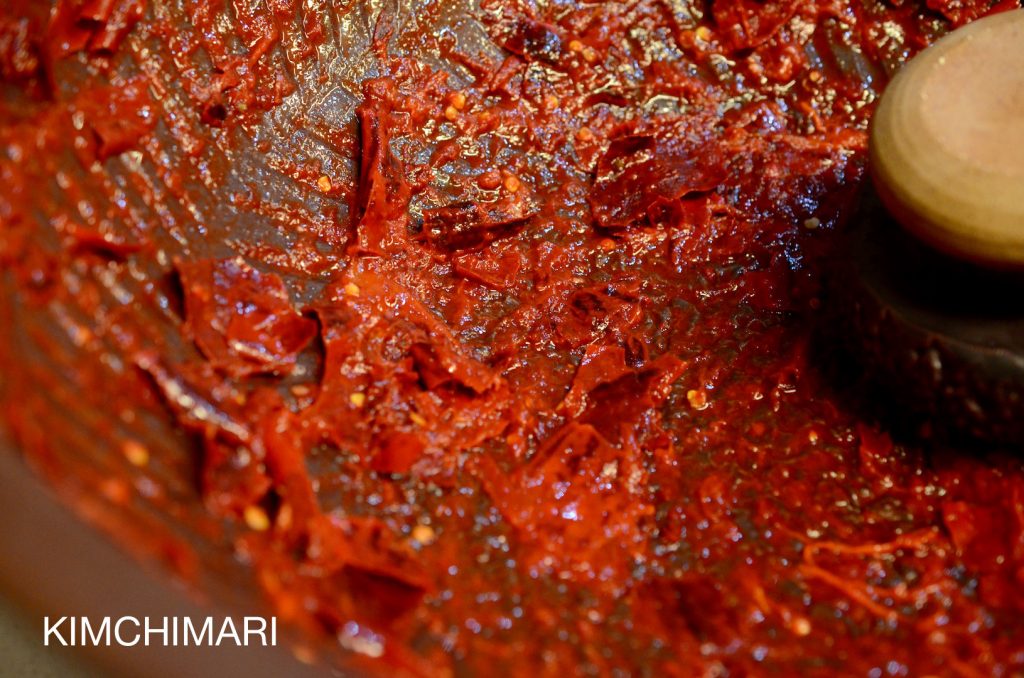 Hand grinding chili pepper for kimchi in Kimchi making bowl