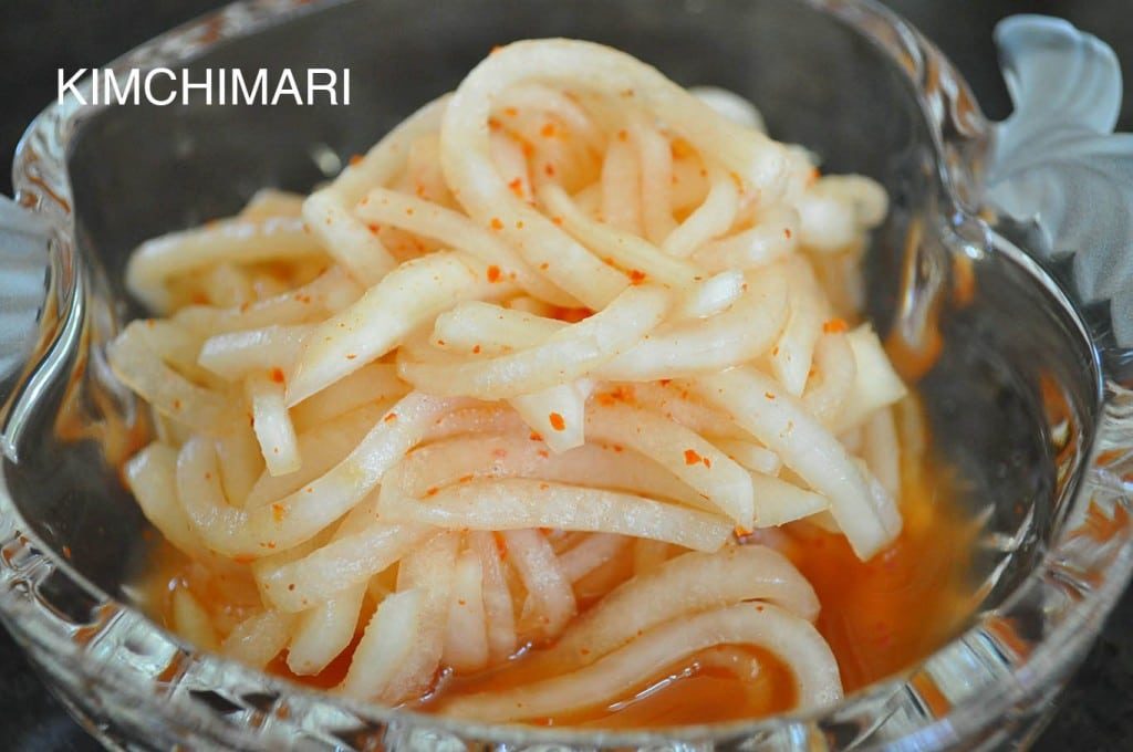 Radish salad with red chili pepper powder in glass bowl