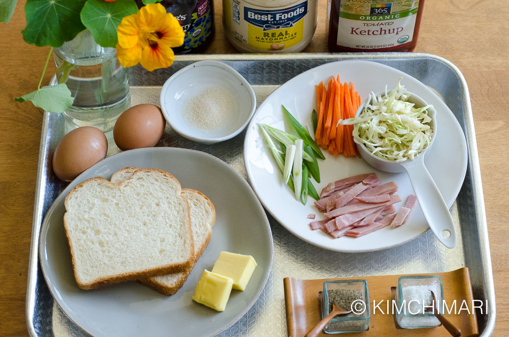 eggs, bread, butter, cut vegetables, salt pepper all laid out on a tray