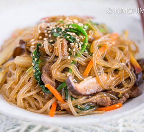 Japchae served in white bowl