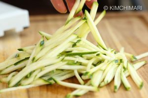 Pile of Julienned Zucchini on wood cutting board