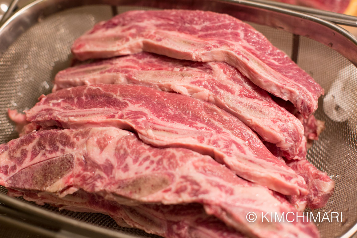 la cut beef short ribs draining in a colander