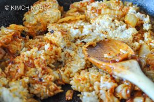 breaking up rice with spatula in frying pan