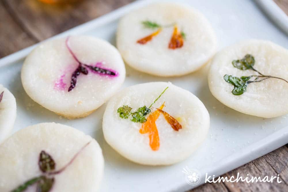 cooked flower pancakes of yellow, purple flowers on white dish 