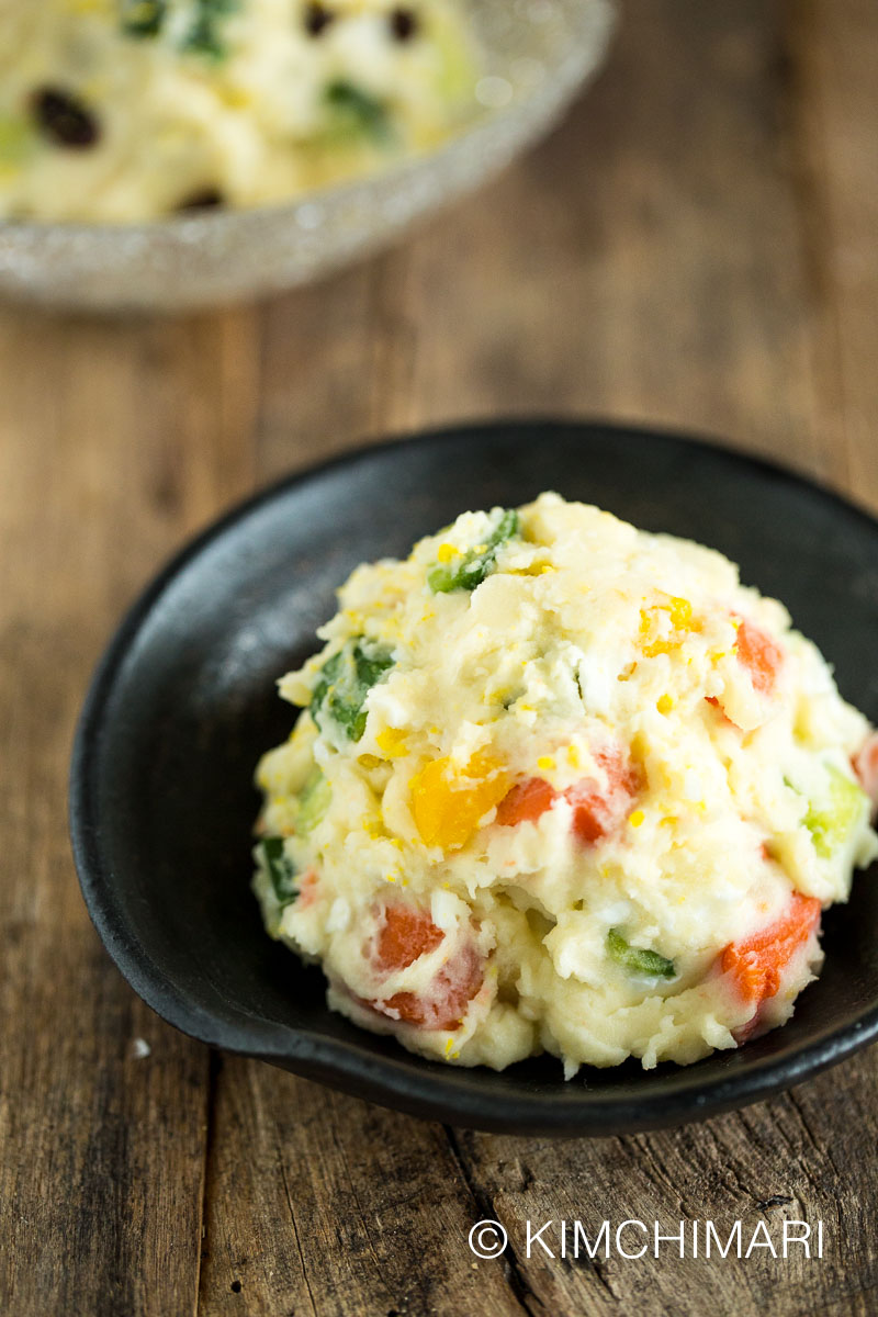 korean potato salad on black dish on wooden table