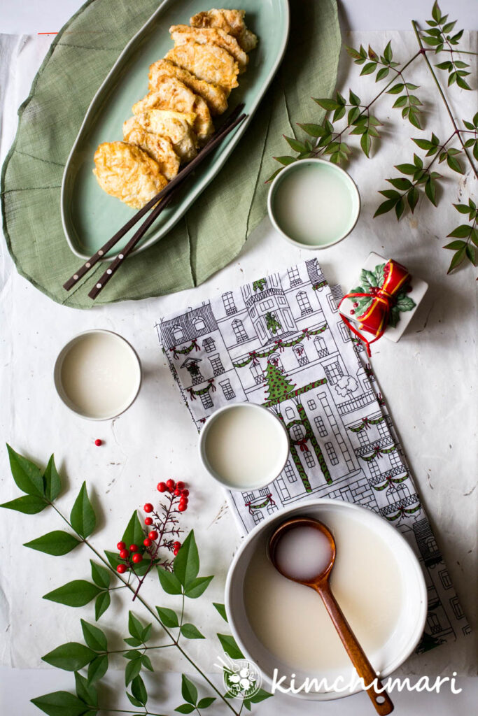 makgeolli served with fish jeon on a table setting with xmas decor