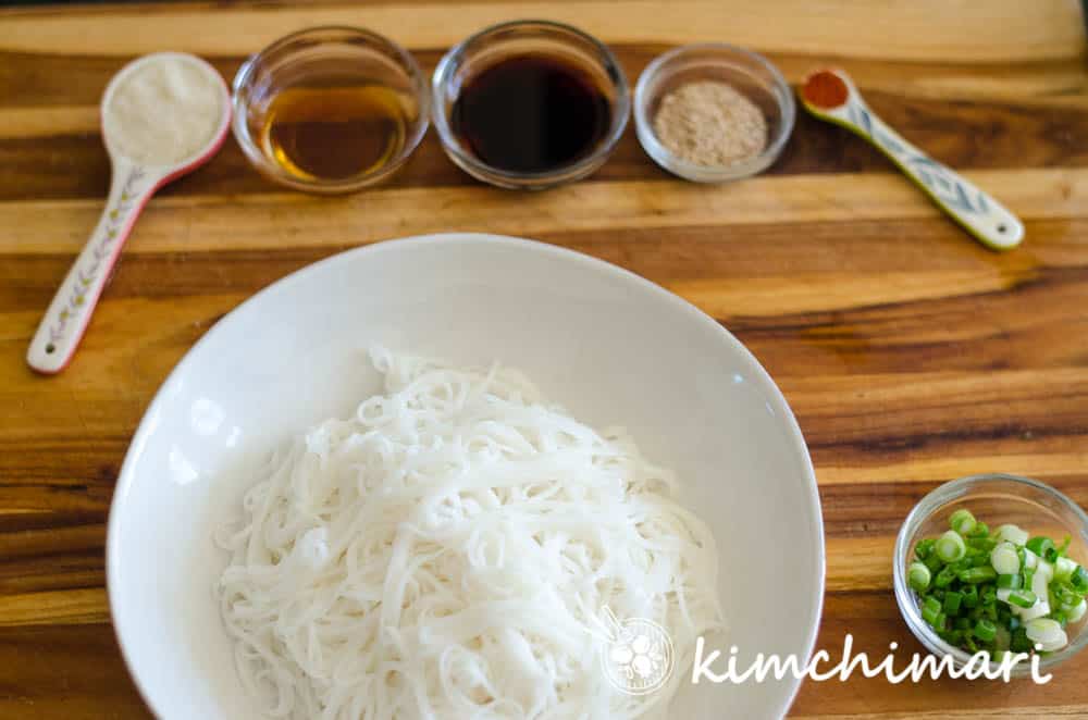 seasonings in little bowls laid out in front of bowl of noodles