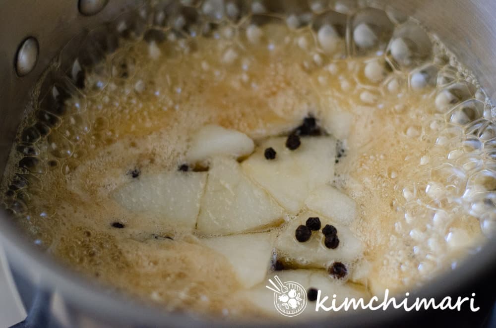 sliced pear with honey simmering in pot