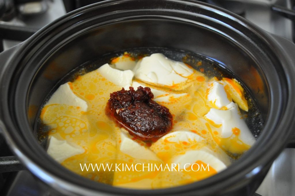 making soondubu jjigae in hot pot with seasoning