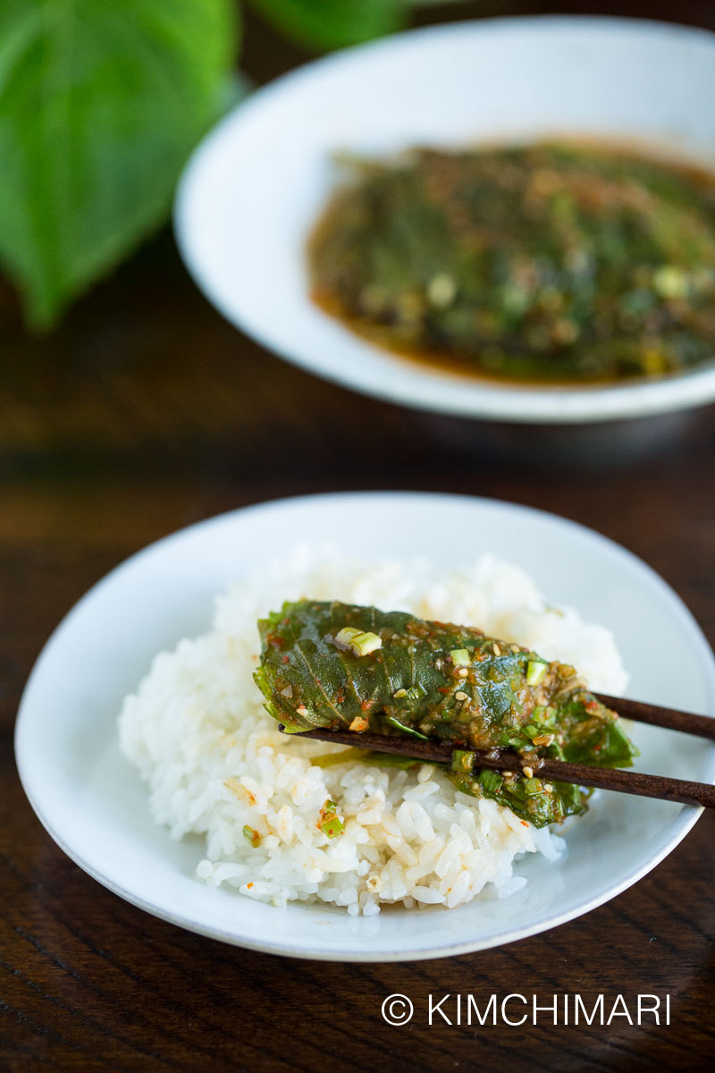 steamed perilla leaf on white rice wrapped around with chopsticks