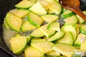 stir-frying seasoned zucchini in frying pan