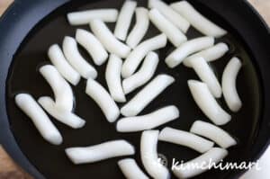 tteokbokki rice cakes in pan with broth